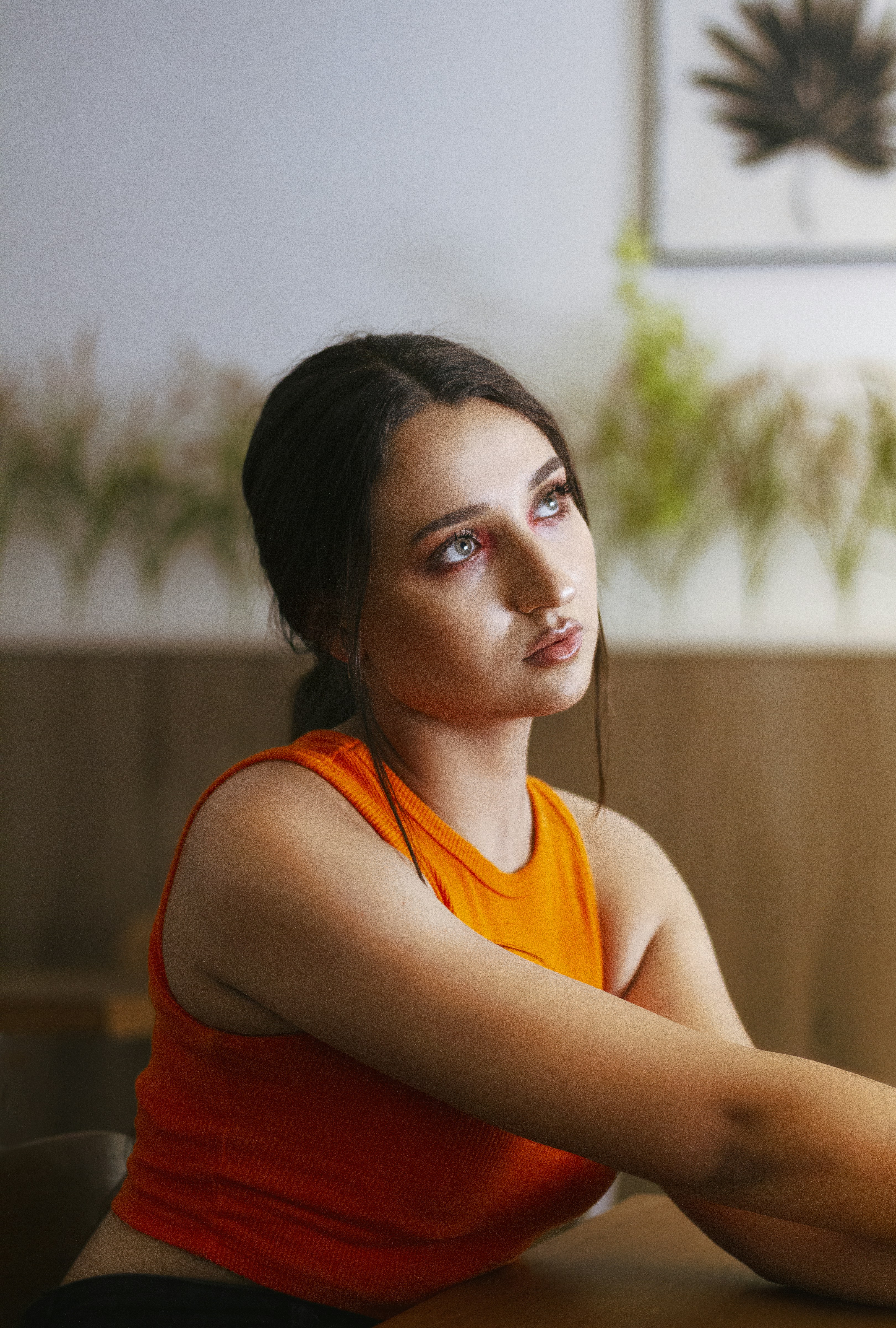 Una mujer sentada en una mesa con los brazos cruzados
