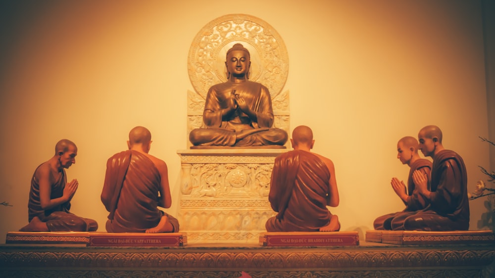 a group of buddha statues sitting on top of a table