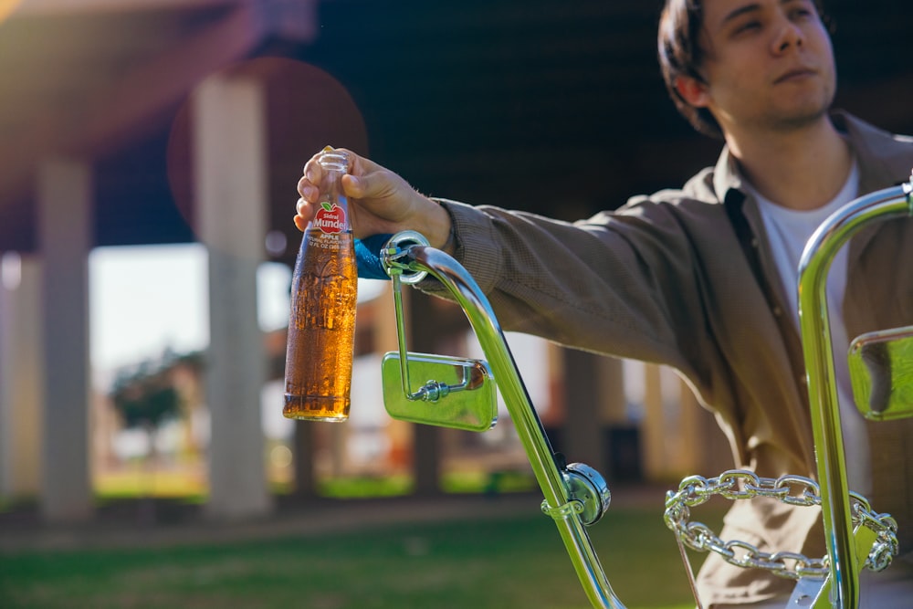 a man holding a bottle of beer on a bike