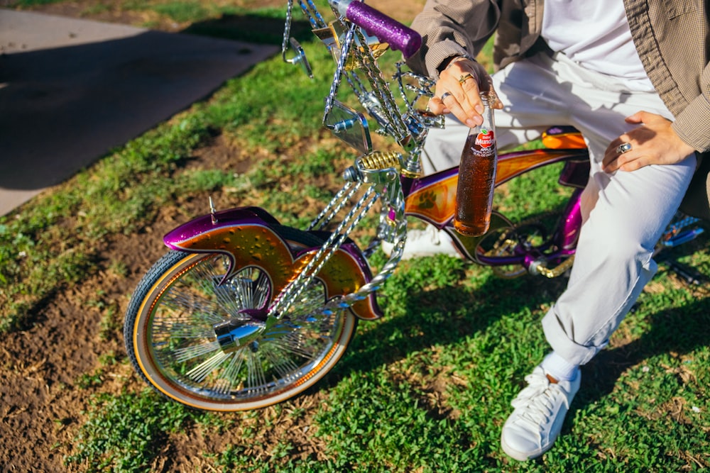 a man sitting on a bike with a bottle of beer attached to it