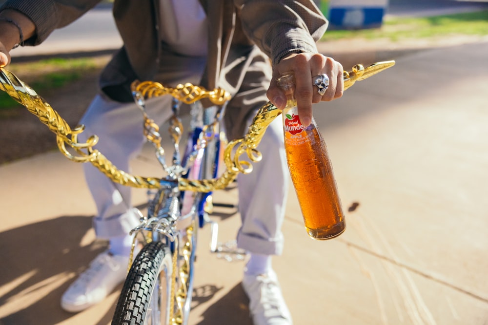 a person on a bike holding a bottle of beer