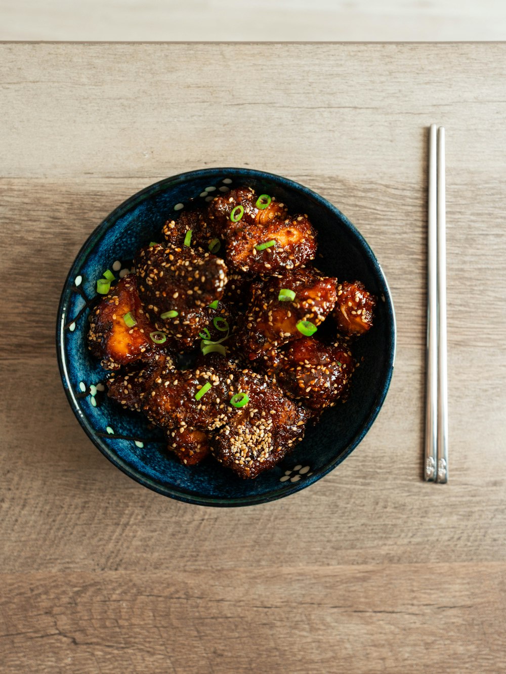 a blue bowl filled with meat and vegetables