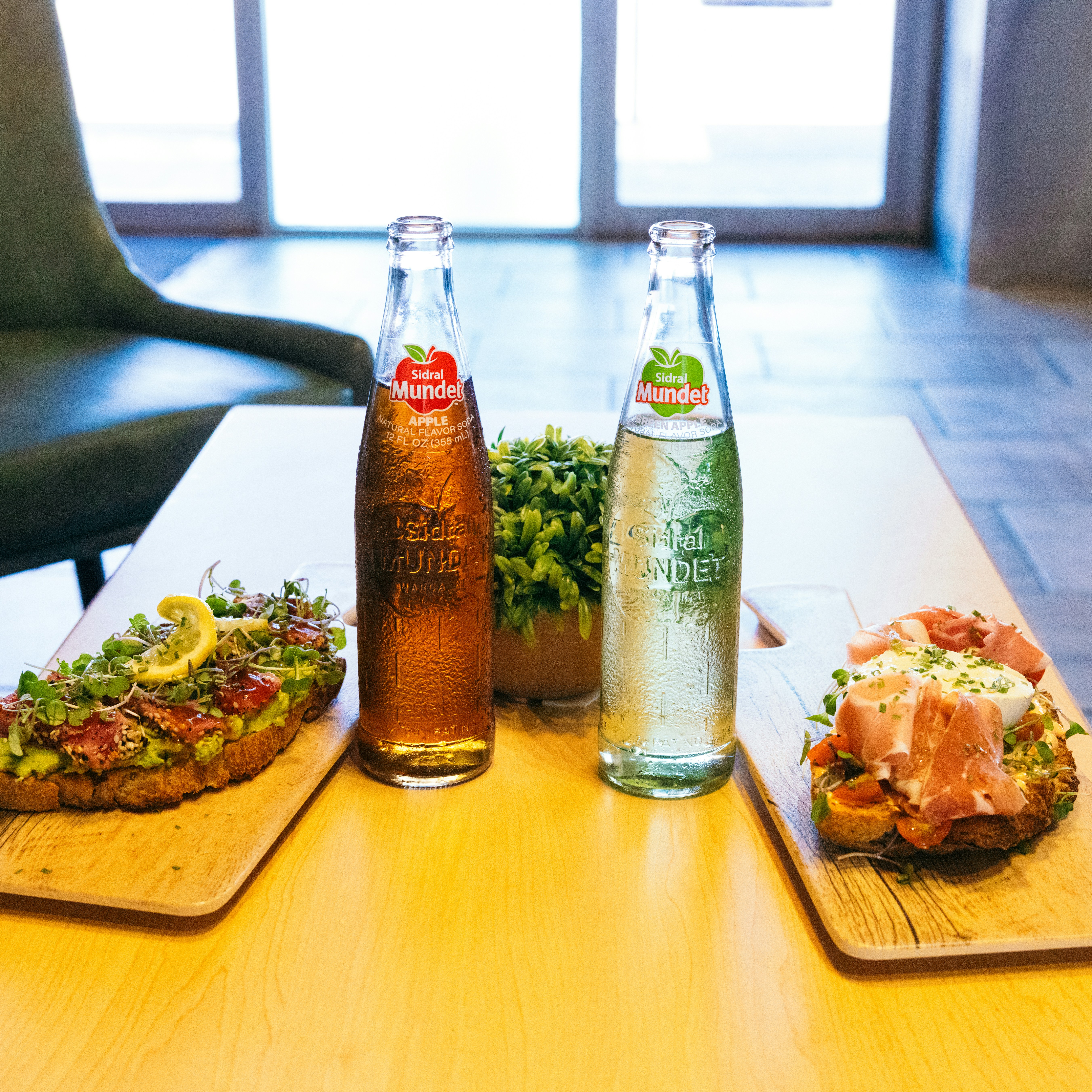 a wooden table topped with two bottles of soda