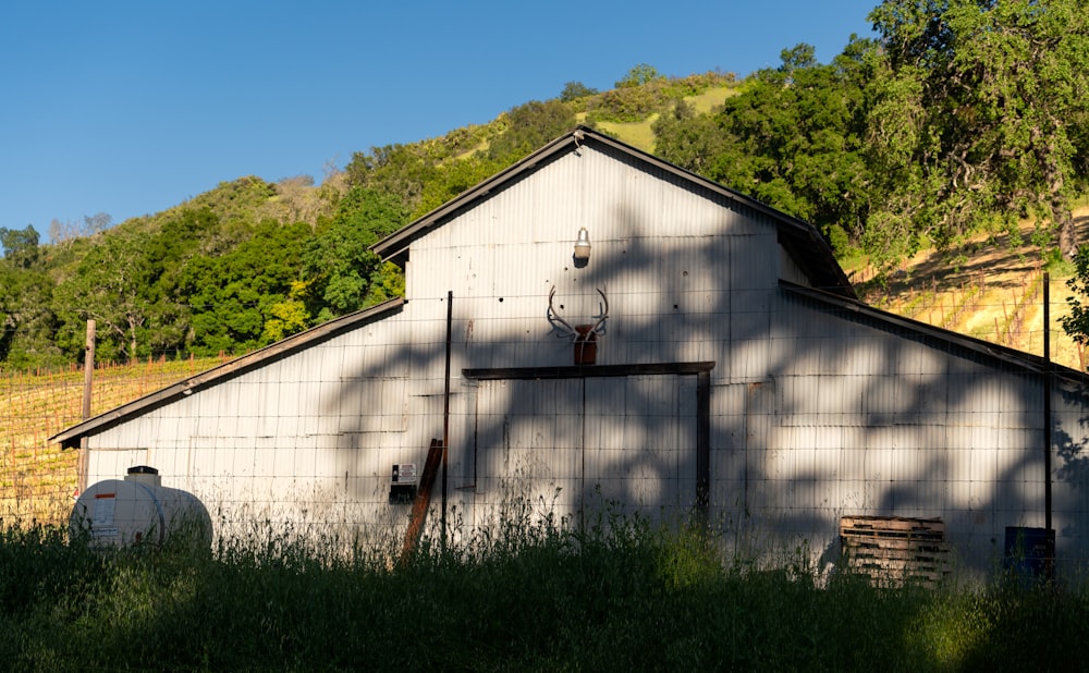 a white barn with a deer antlers on the roof