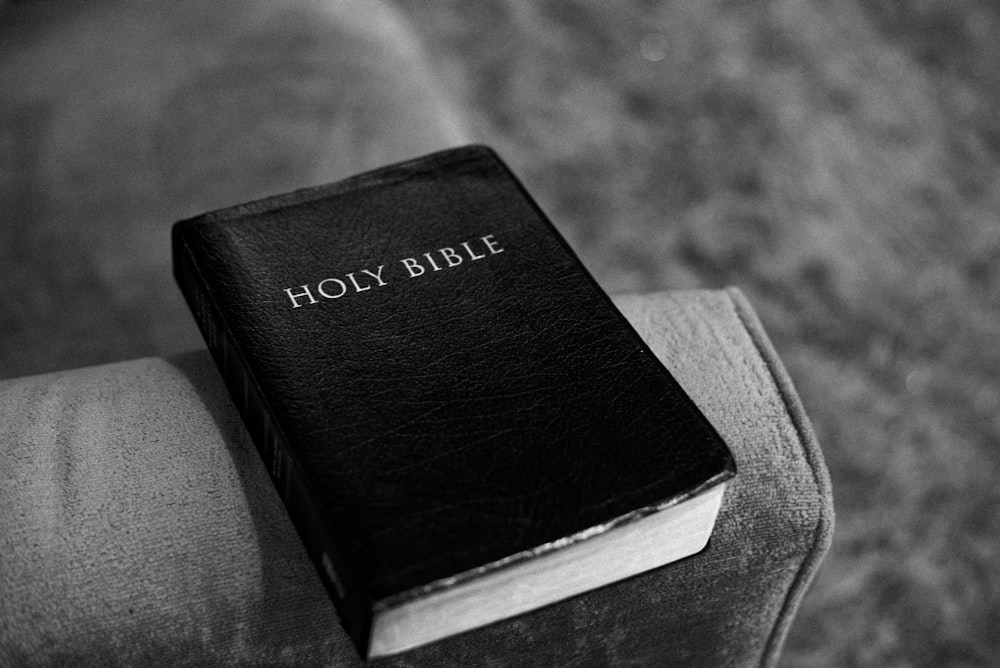 a black and white photo of a bible on a couch