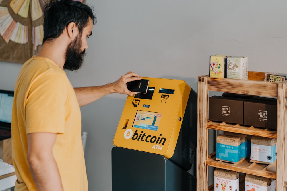 a man putting a bitcoin machine into a bin