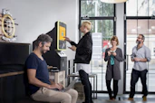 Friendly community members exchanging services and smiling, connected by a digital credit system board.