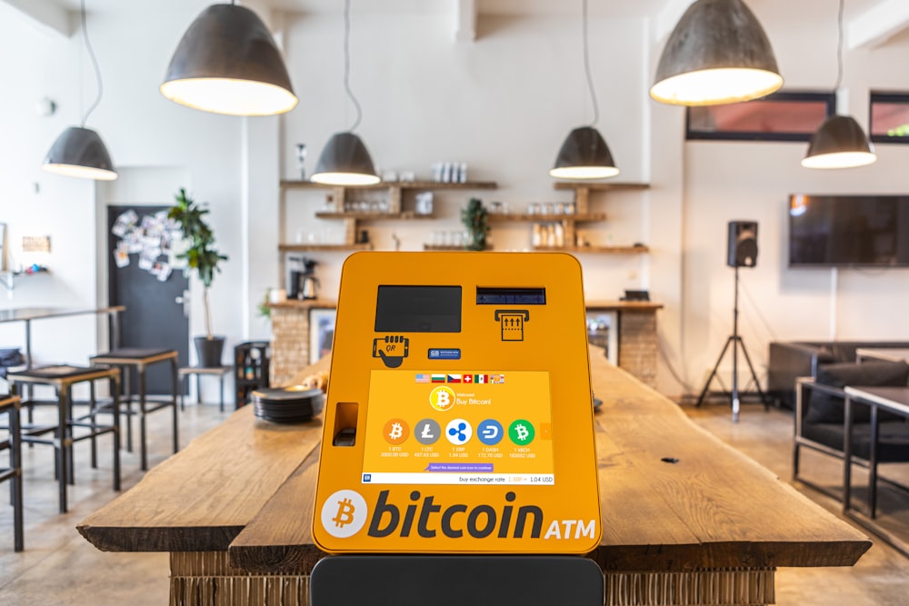 Un cajero automático de bitcoin sentado encima de una mesa de madera