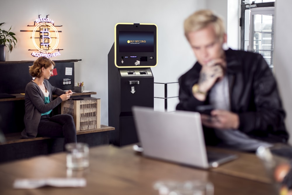 a man and a woman sitting at a table with a laptop