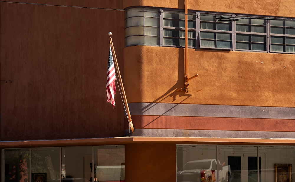 an american flag on a pole in front of a building
