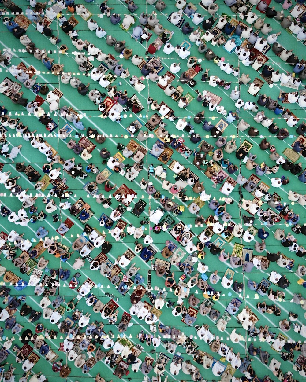 a large group of people standing around a green field