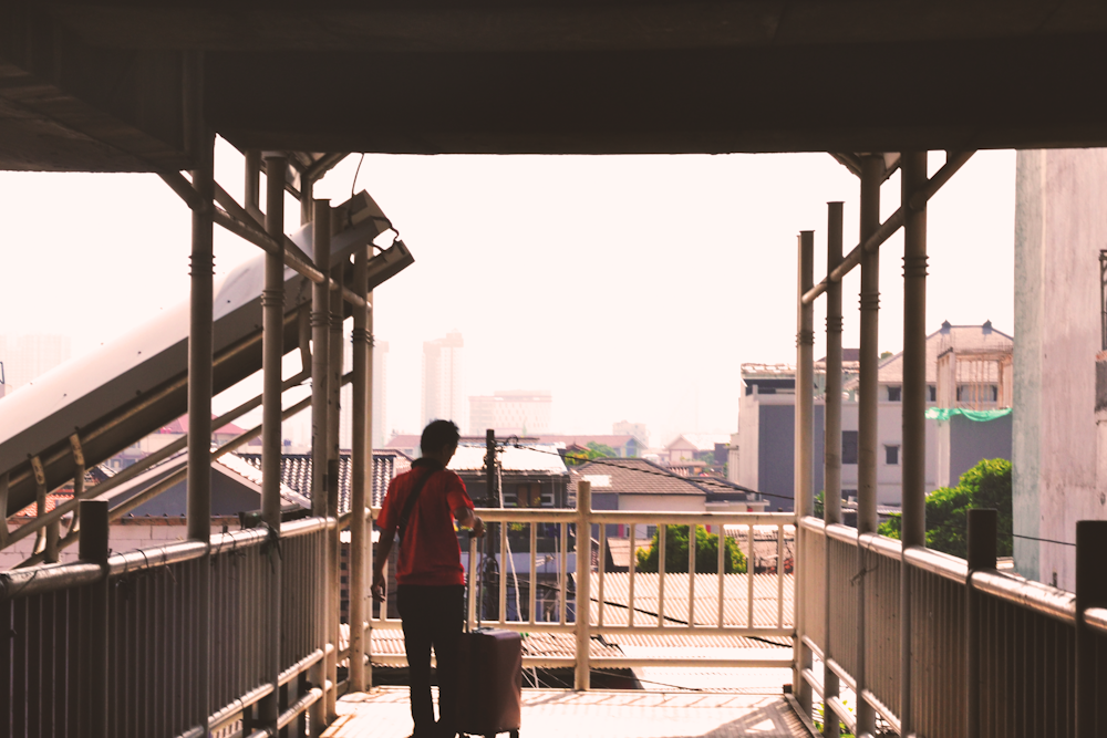 a person standing on a walkway with a suitcase