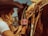 A person, wearing a cowboy hat and a white shirt, is holding a bottle of Senorial Sangria flavored soda while standing next to a saddled horse. The scene has a rustic, Western vibe with warm sunlight casting a golden hue over the setting.