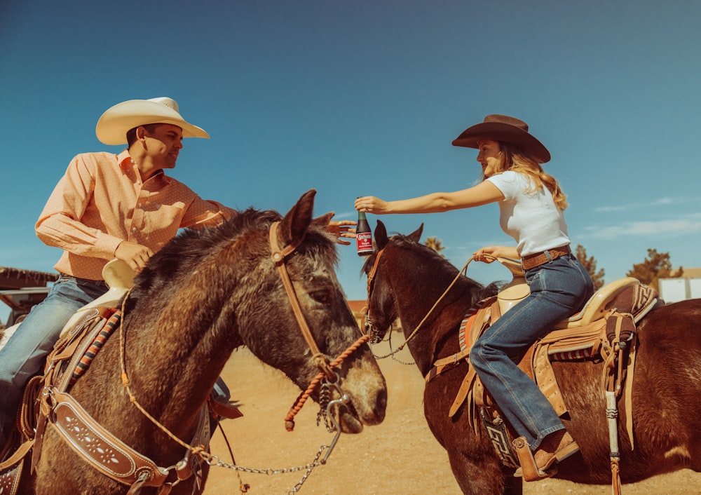 a man and a woman riding on the backs of horses