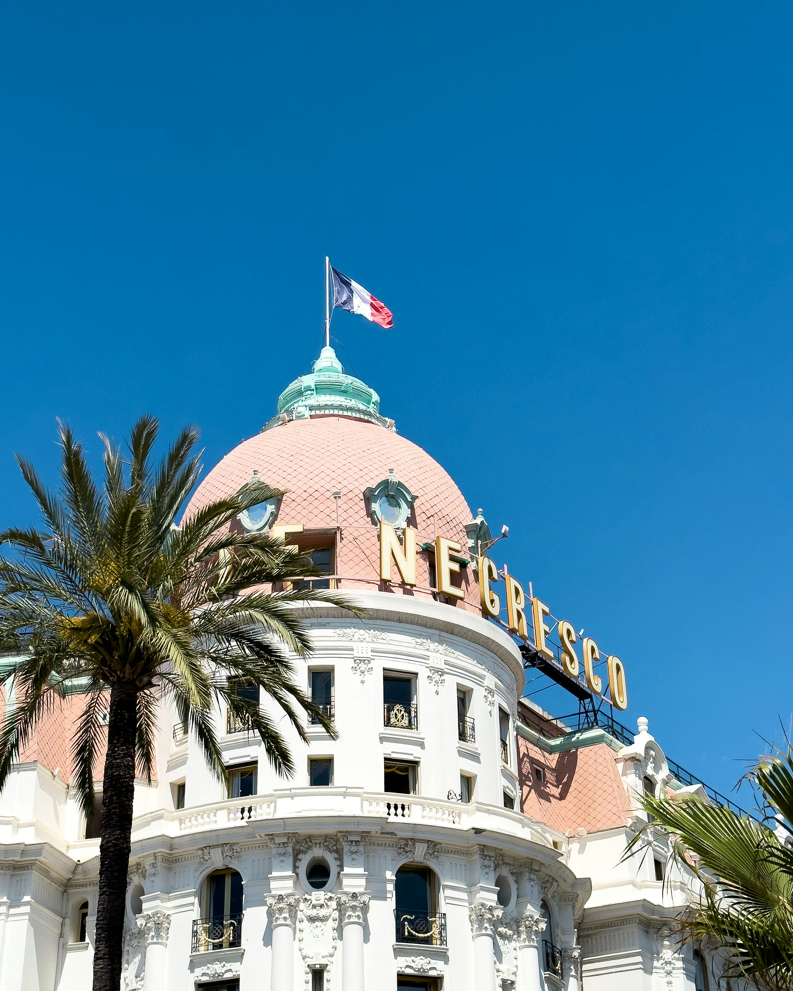 A large white building with a flag on top of it photo – Free Building ...