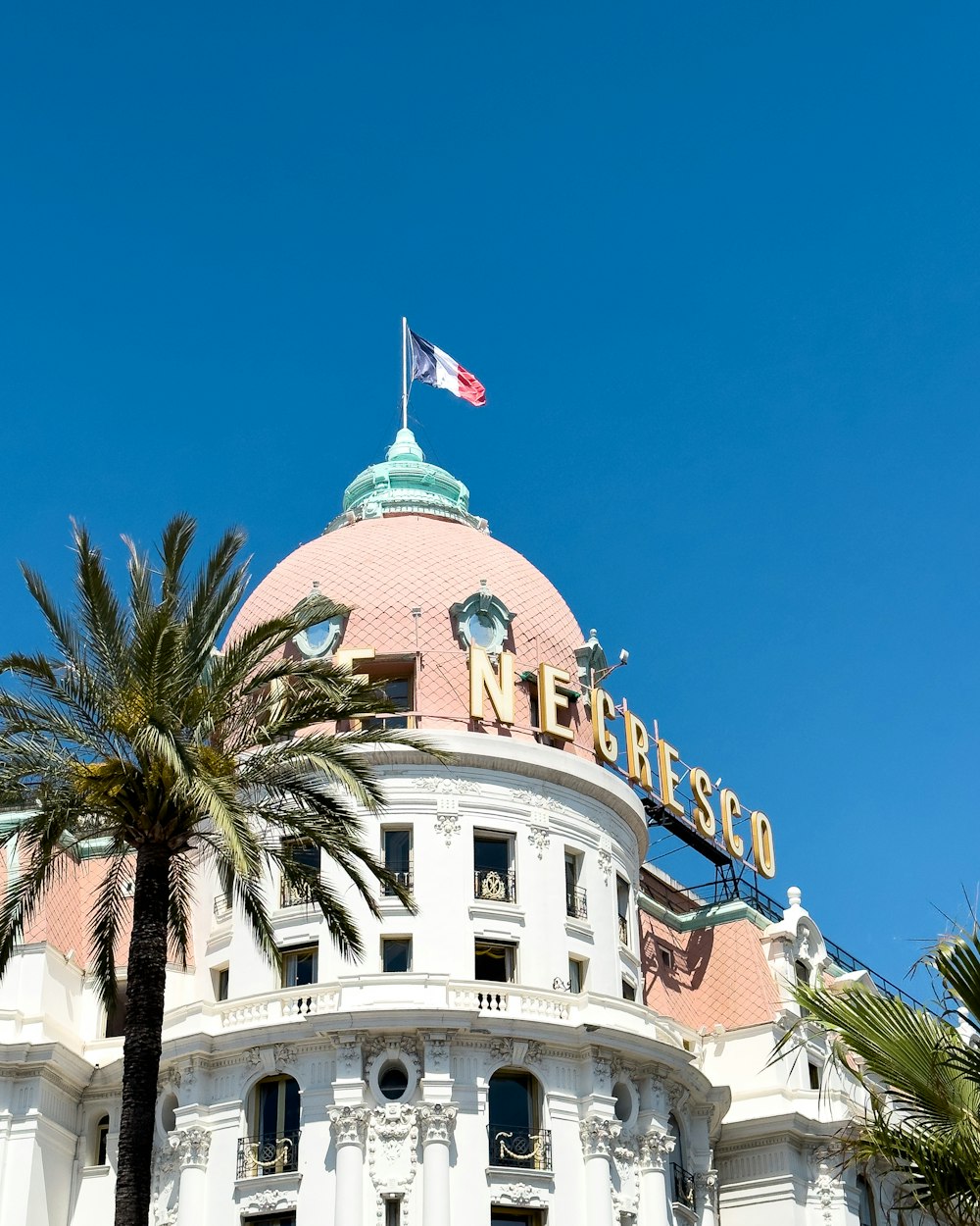 a large white building with a flag on top of it