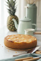 A golden pineapple upside-down cake fresh out of the oven with caramelized fruit on top.