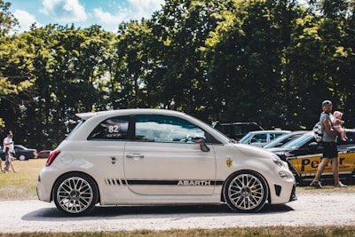 a small white car parked in a parking lot