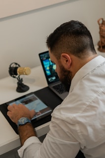 a man sitting at a desk using a tablet
