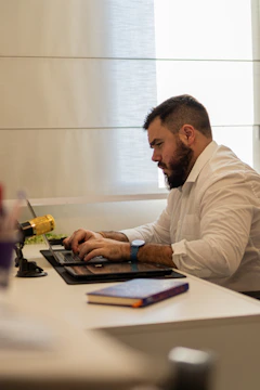 a man sitting at a table using a laptop computer