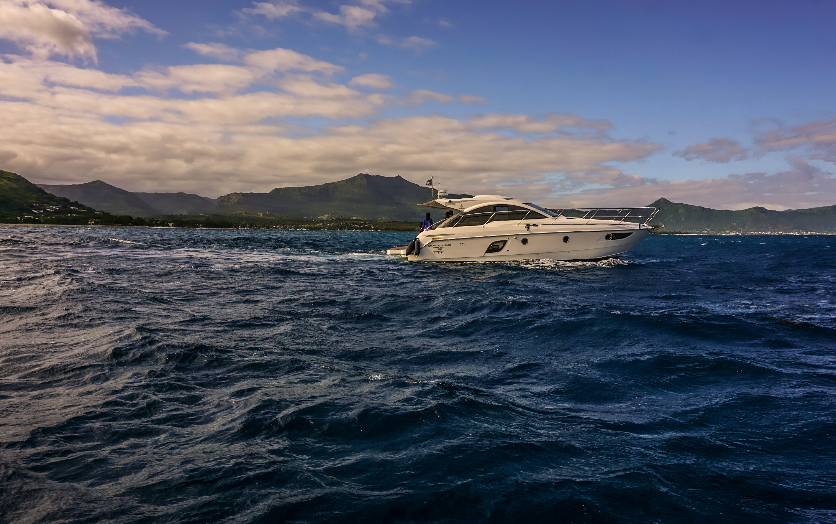 a white boat in the middle of a body of water, 