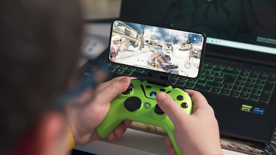 a person playing a video game on a laptop, Playing games on phone with gamepad