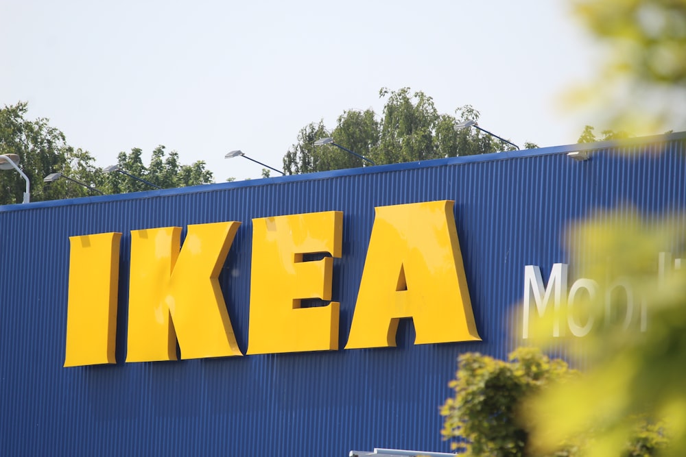 a blue and yellow ikea building with trees in the background