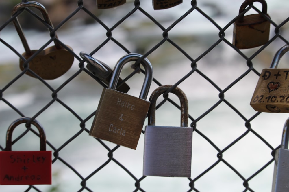 a bunch of padlocks attached to a fence