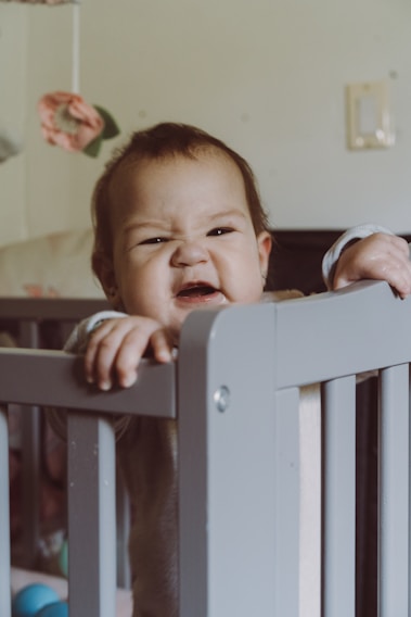 A cozy baby crib attached securely to an adult bed, showcasing the adjustable height feature.