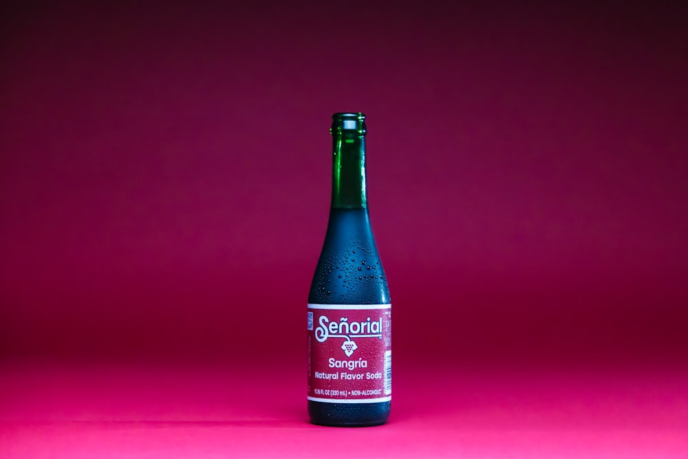 a bottle of beer on a pink background