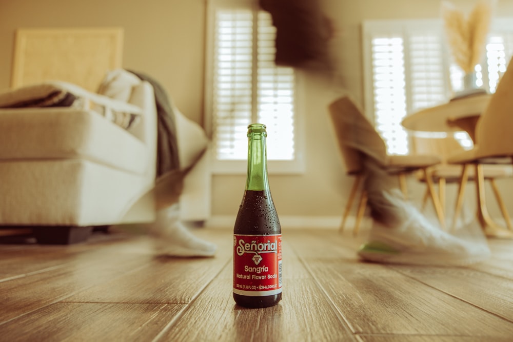 a bottle of beer sitting on top of a wooden floor