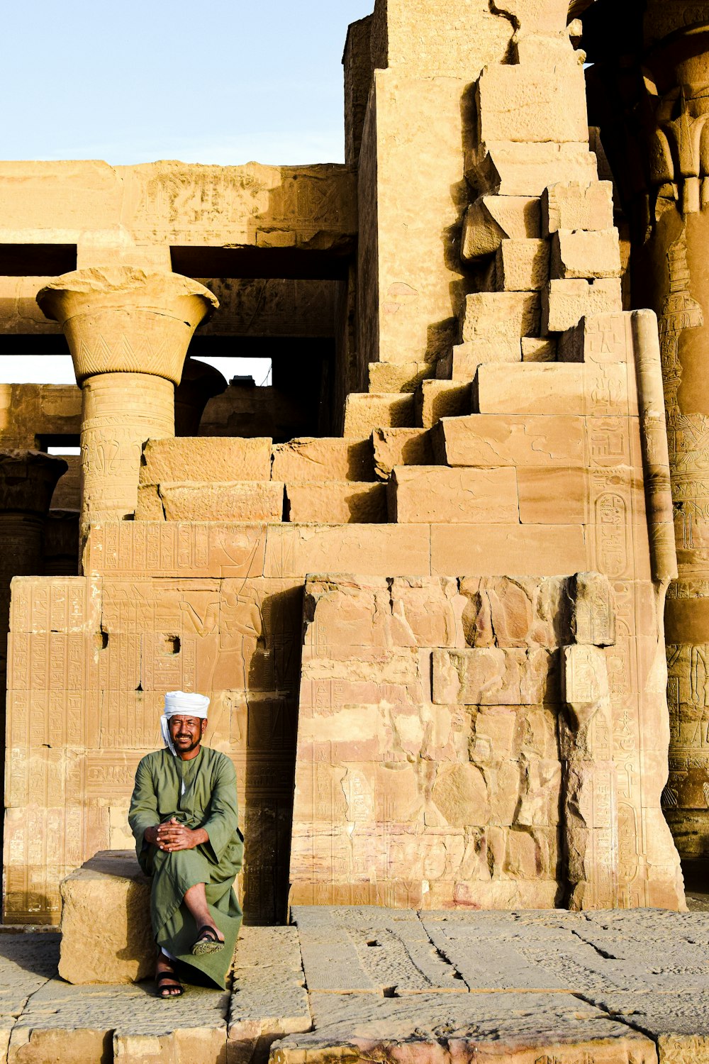 a man sitting on a ledge in front of a building