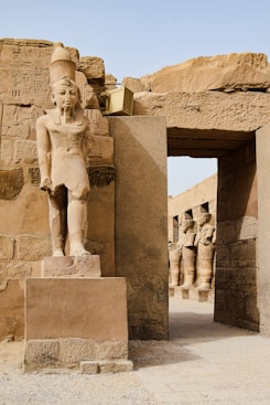 a statue of an egyptian god in front of a doorway