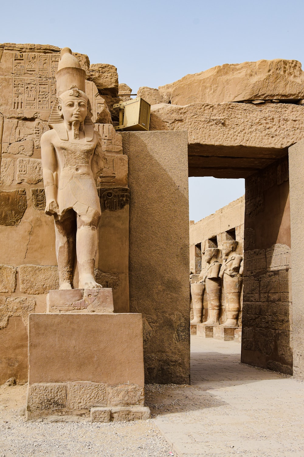a statue of an egyptian god in front of a doorway