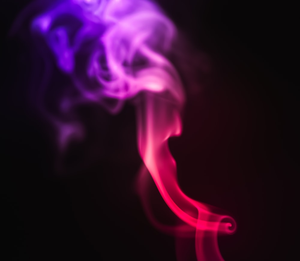 a red and purple smoke is on a black background