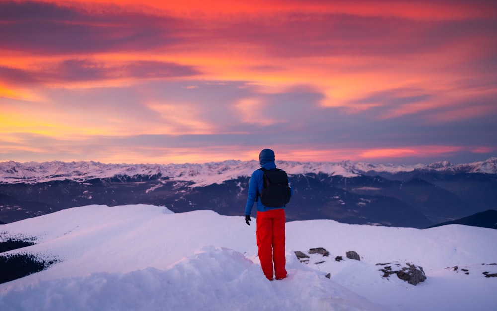 a man standing on top of a snow covered mountain