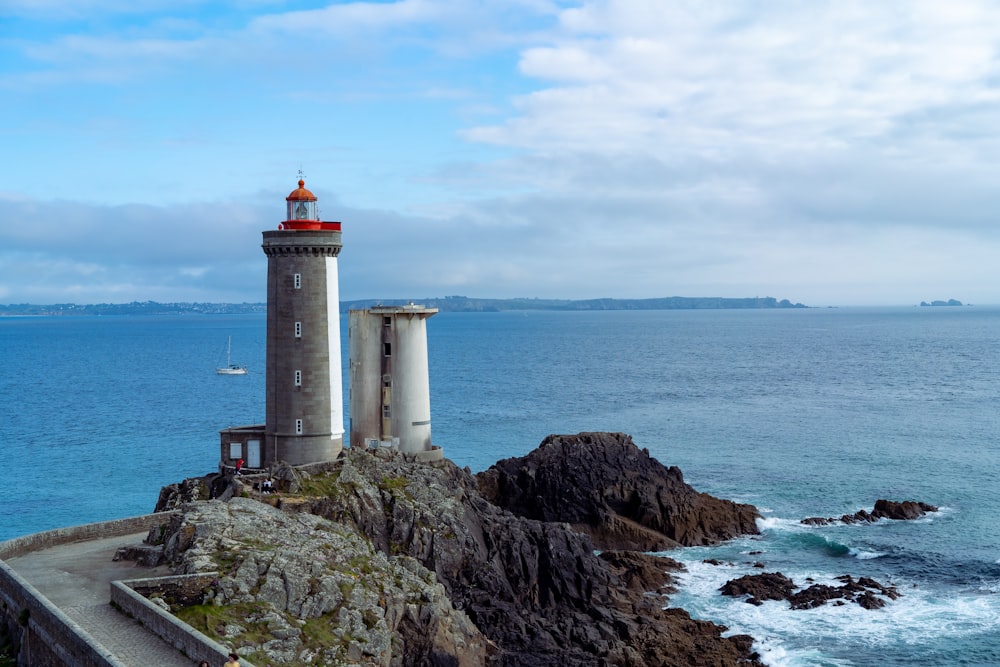 a light house sitting on top of a cliff next to the ocean