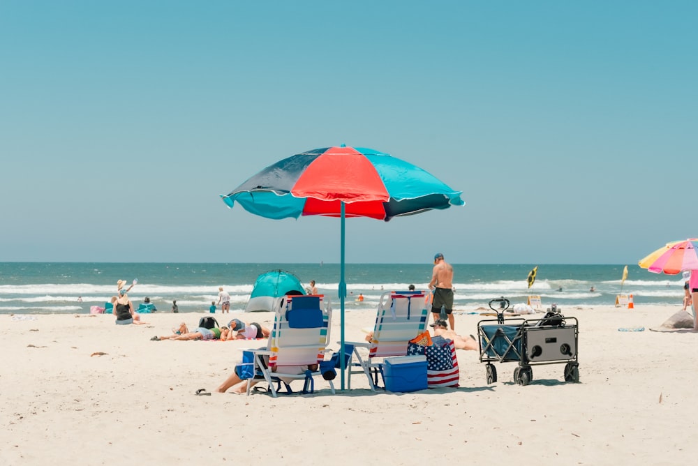 a group of people sitting on top of a sandy beach