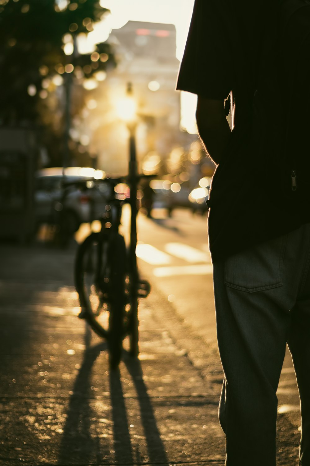 a man standing on a sidewalk next to a bike