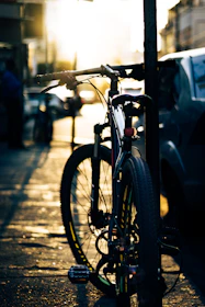 Close-up of an e-bike at an urban bike rack during golden hour.