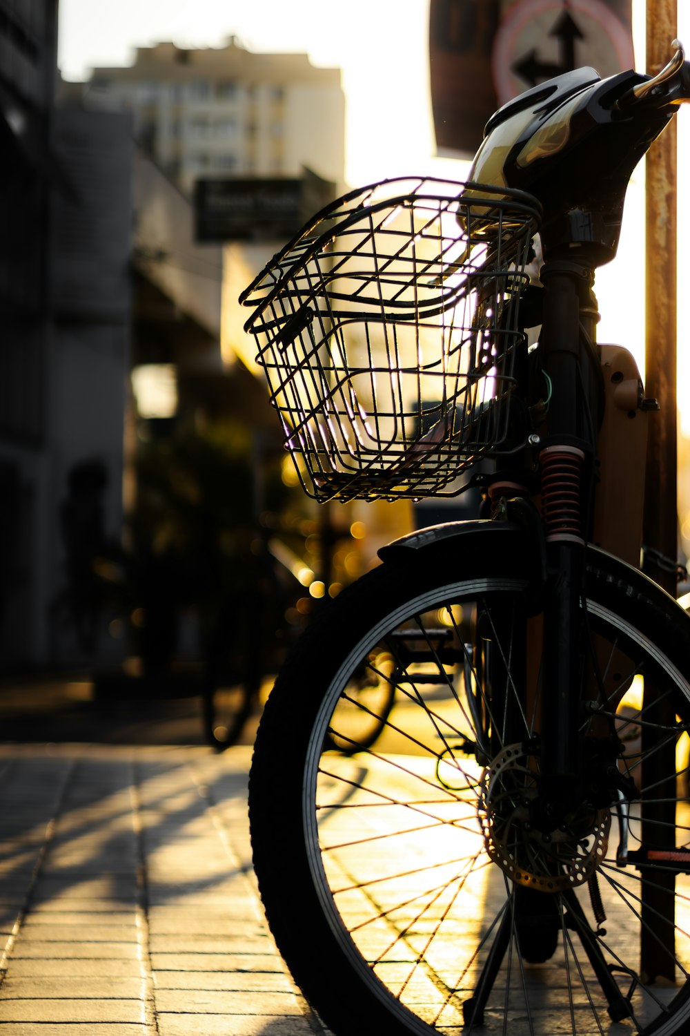 a bicycle with a basket parked on a sidewalk