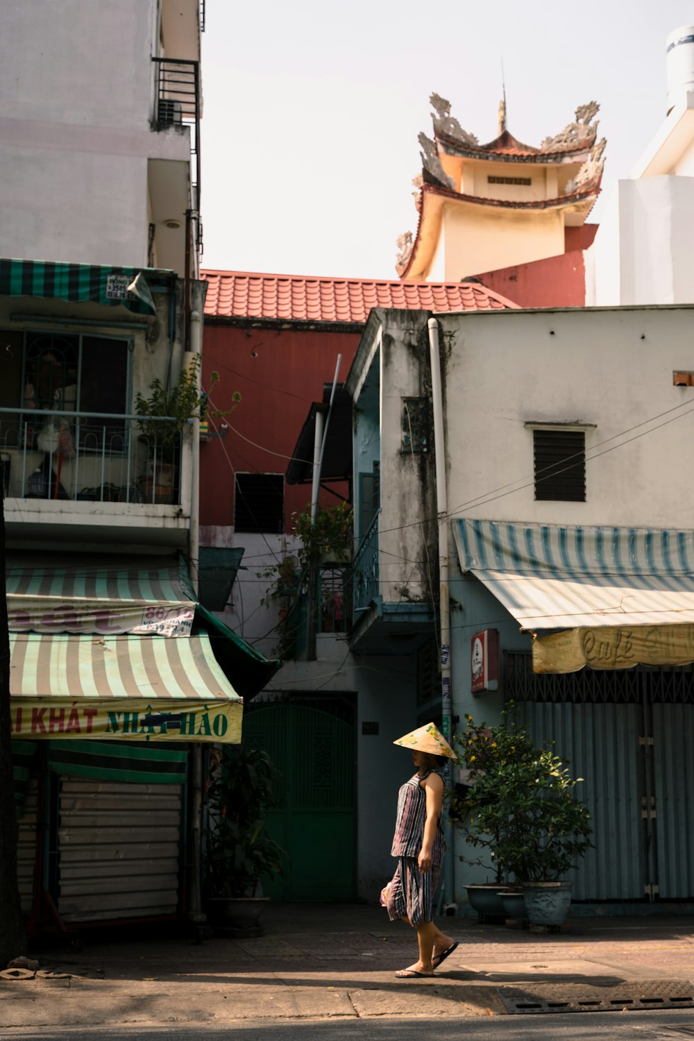a woman in a yellow hat walking down a street