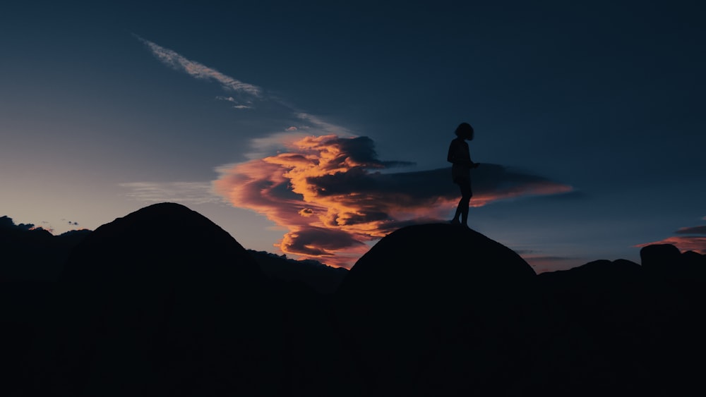 a person standing on top of a mountain at sunset