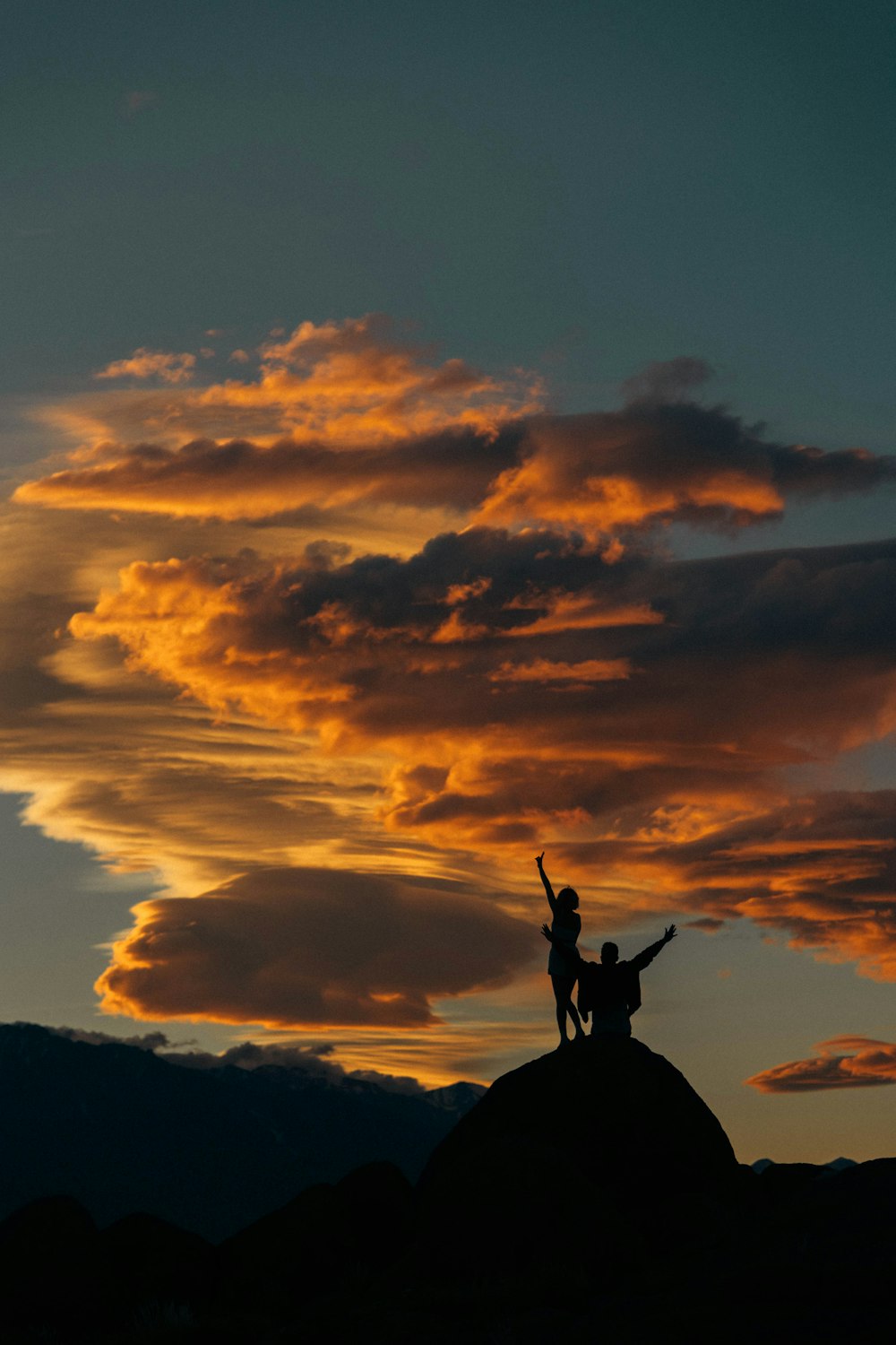 a couple of people standing on top of a hill