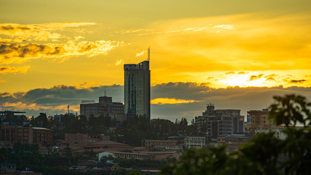 the sun is setting over a city with tall buildings