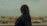 a woman standing on top of a building looking at a city
