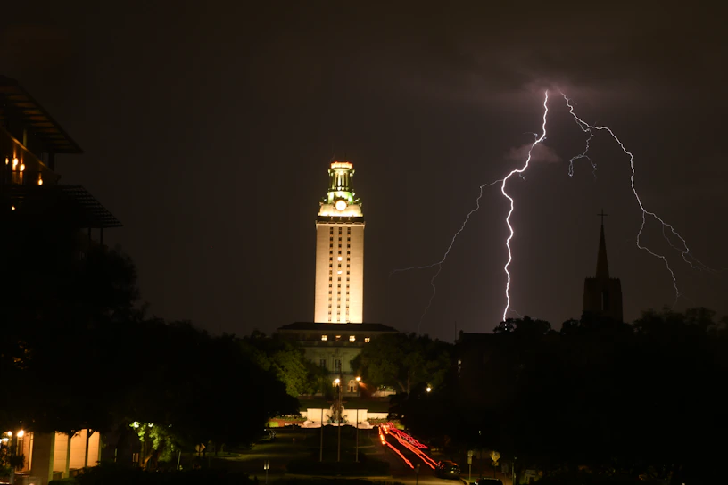 A close-up of The Tower tarot card showing a lightning strike and falling figures against a dark sky.