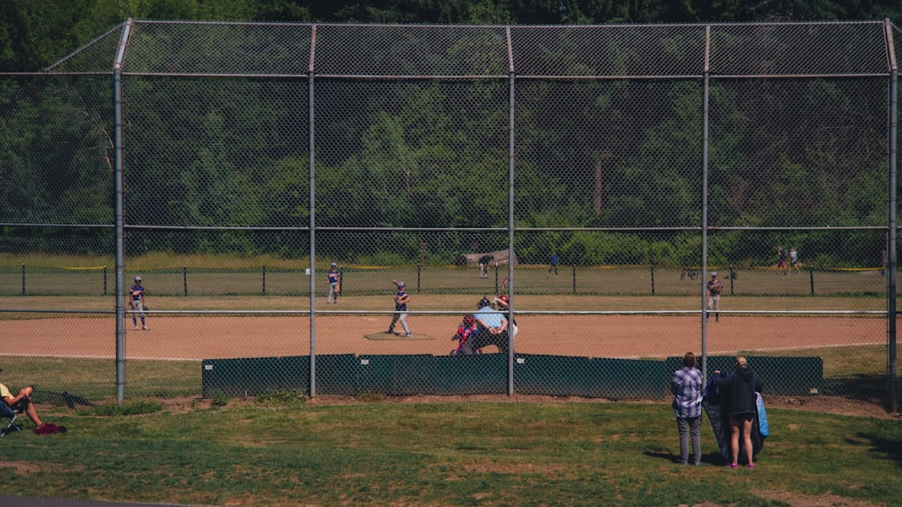 Un grupo de personas de pie en la parte superior de un campo de béisbol