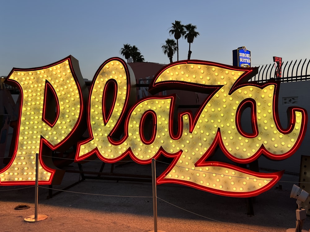 a large sign that says plaza in front of a fence