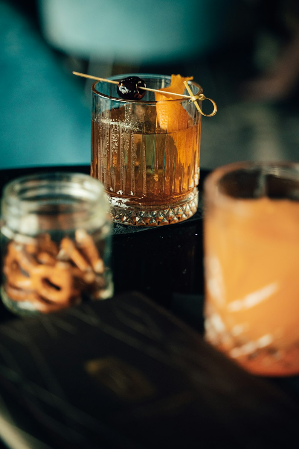 a glass with a drink and some crackers on a table